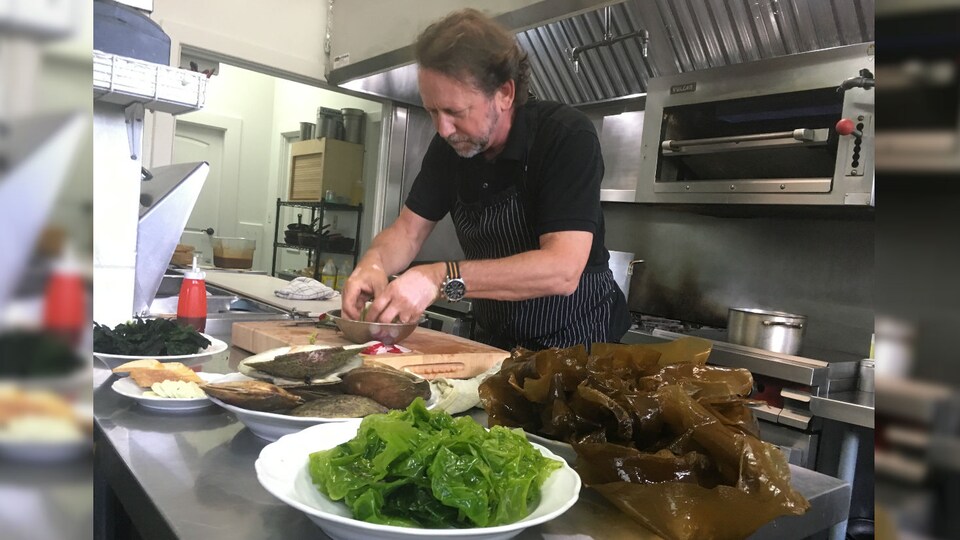Le chef cuisine avec des algues.