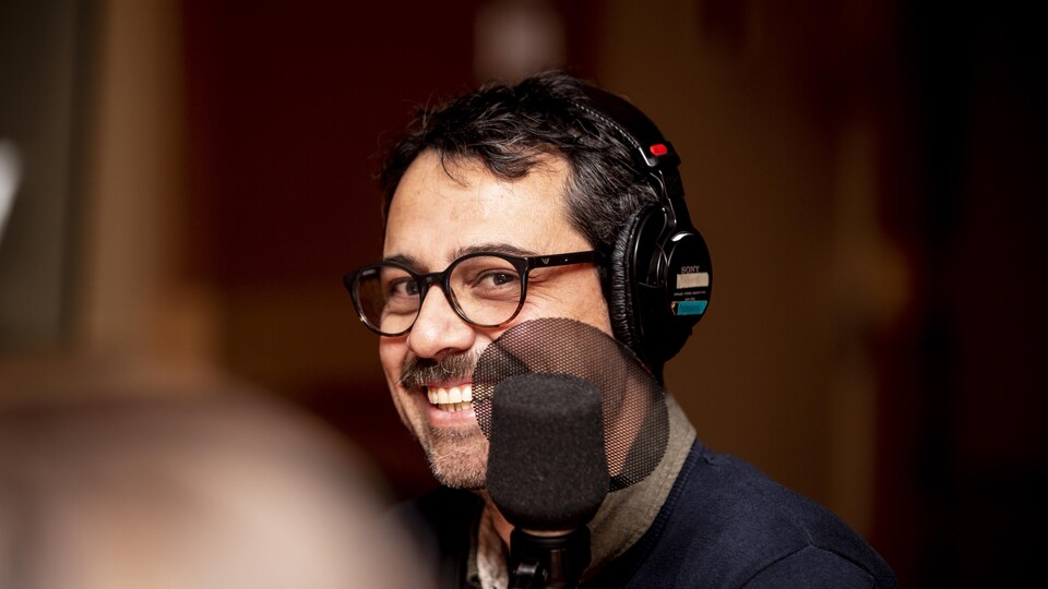Il sourit au micro. 