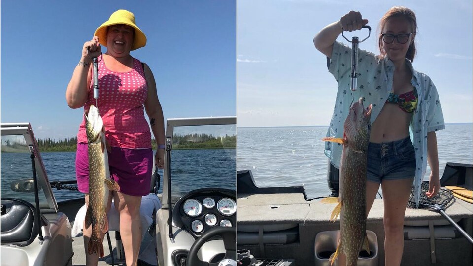 Deux femmes tiennent chacune un gros poisson qu'elles ont pêché.