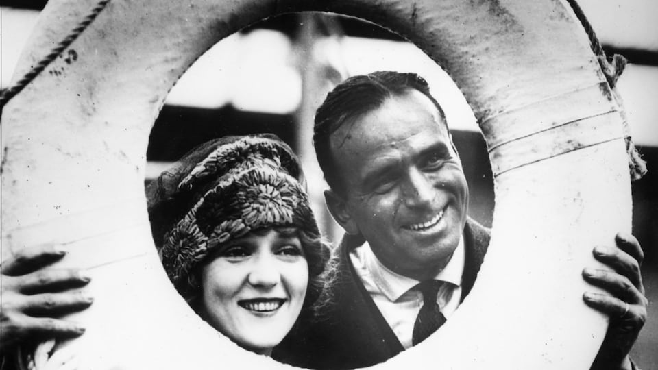 Douglas Fairbanks et Mary Pickford posent derrière une bouée de sauvetage en 1920.