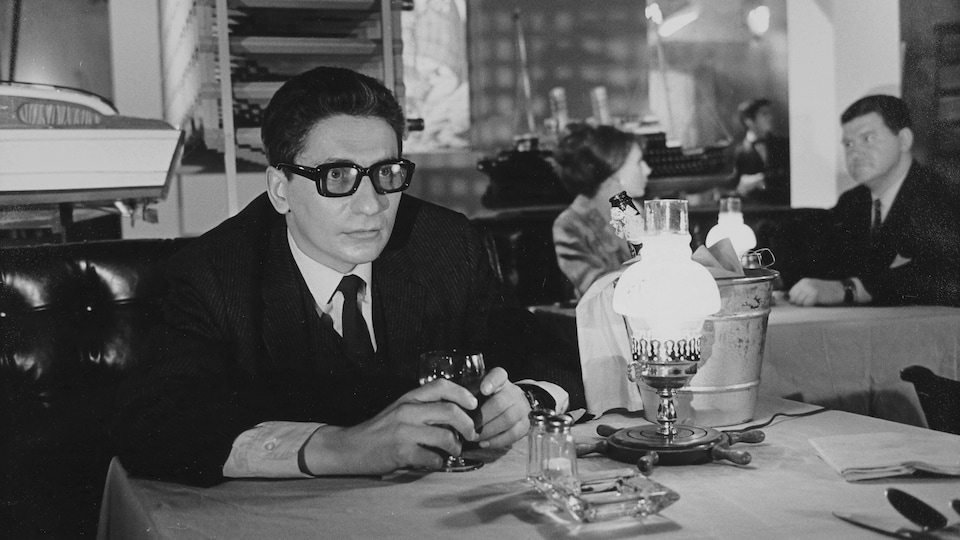 Hubert Aquin assis à une table de restaurant dans le film Faux bond (1966), de Louis-Georges Carrier.