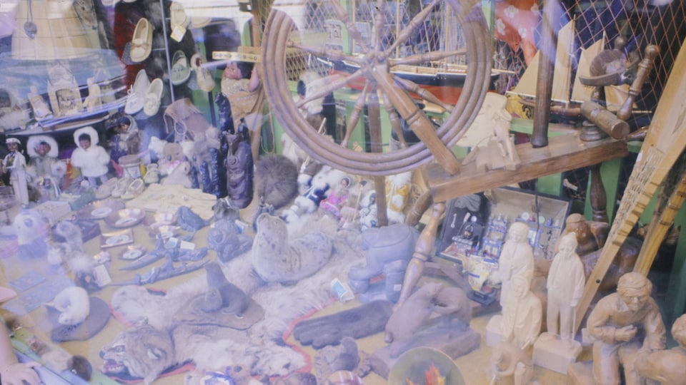 Des objets d'art traditionnel québécois exposés dans la vitrine d'un magasin.