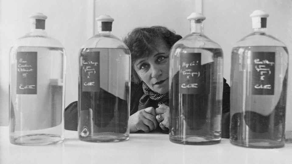 L'auteure Colette entourée de fioles.