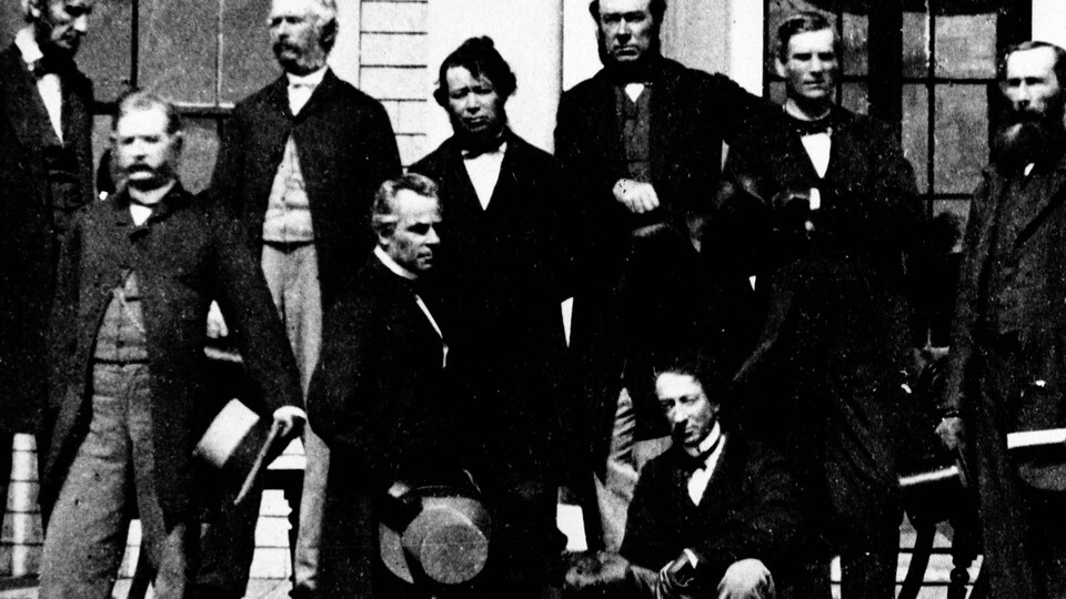Photo d'époque en noir et blanc montrant les dignitaires qui prennent la pose pour la photo officielle.