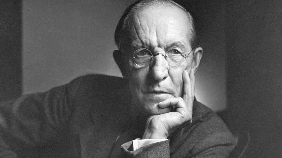 Duncan Campbell Scott pose pour le photographe Yousuf Karsh, assis sur une chaise.