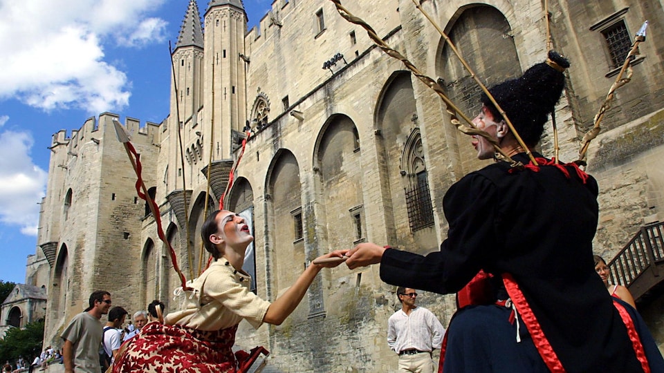 Des acteurs jouent devant le Palais des papes à Avignon, en juillet 2001.