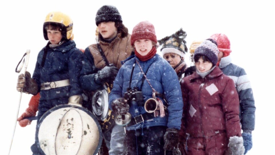 Sept personnages du film La guerre des tuques sont dehors en hiver.