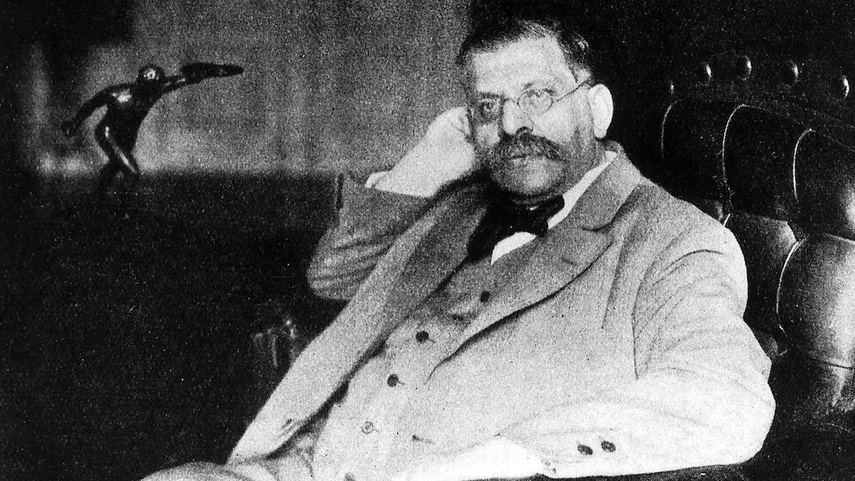 Magnus Hirschfeld assis dans un fauteuil.