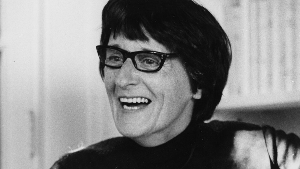 Françoise Loranger regarde à droite en souriant.