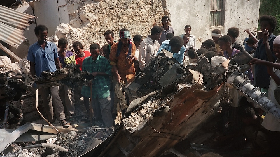 Le 4 octobre 1993, à Mogadiscio, des Somaliens entourent la carcasse d'un hélicoptère de l'armée américaine.