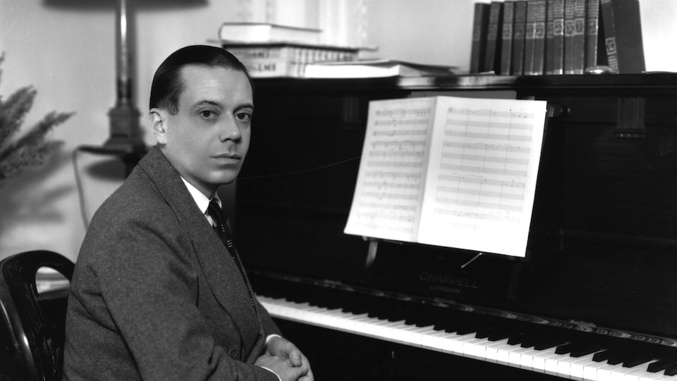 Le compositeur et parolier Cole Porter, assis à un piano.