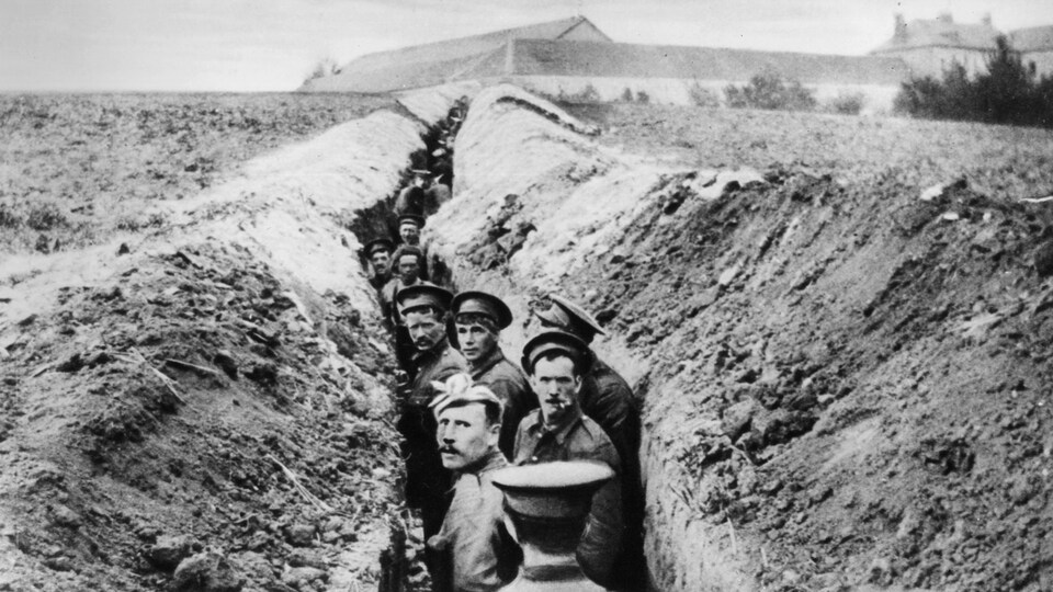 Des soldats britanniques dans une tranchée étroite durant la Première guerre mondiale.