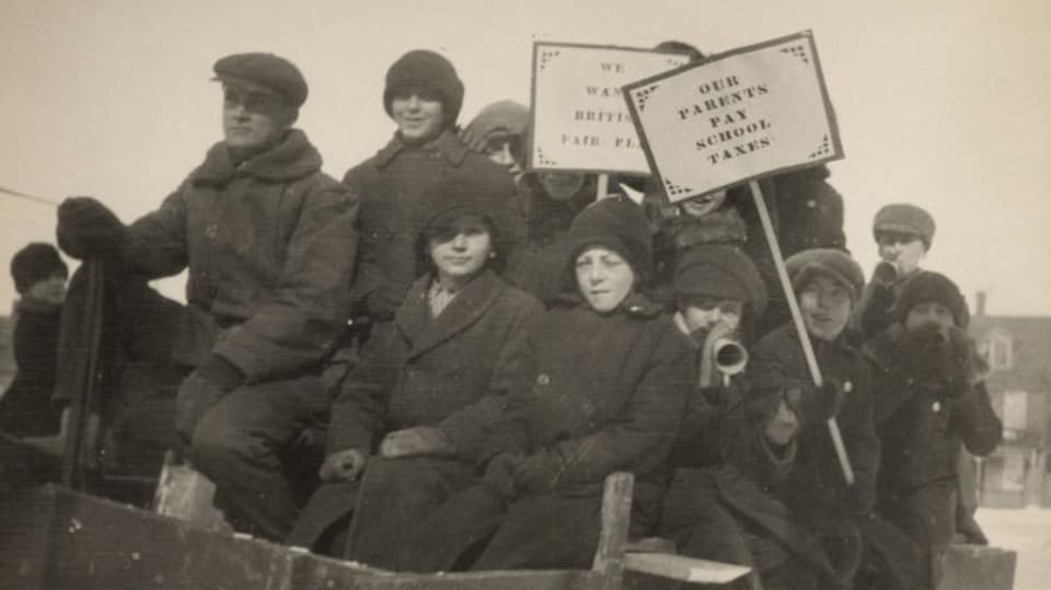 Des écoliers vêtus de manteaux tiennent des pancartes militantes.