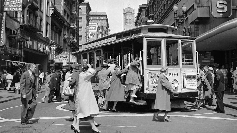 Des citadins montant dans un wagon de tramway en 1953.