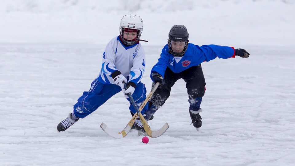 Des enfants sur une patinoire extérieure.