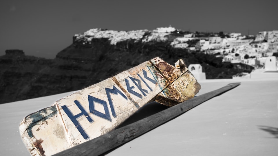 Une place de bois usée ou Homeric Poem's est incrit. La plaque est sur un bateau au large de la Grèce.