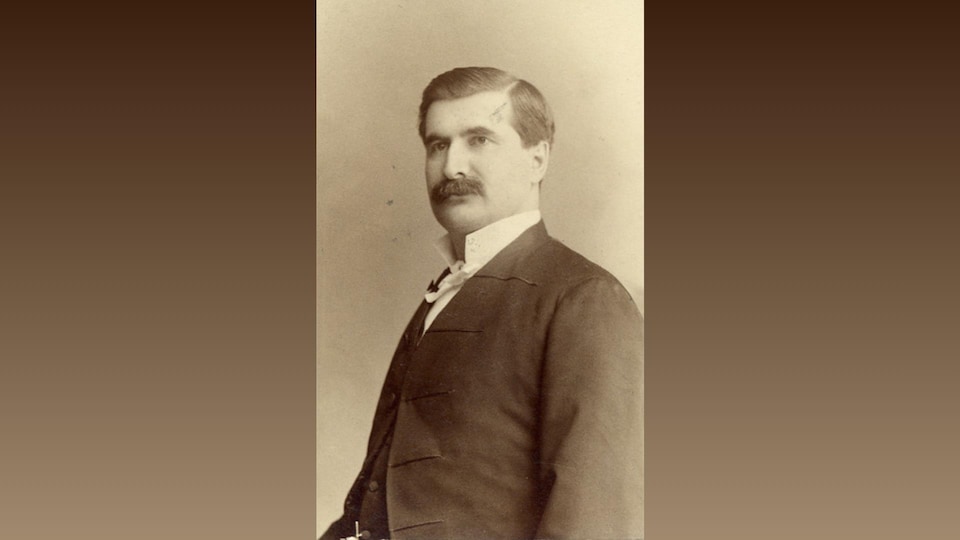Portrait en noir et blanc d'un homme portant une moustache.