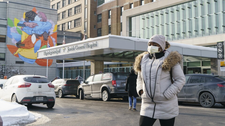 Une femme se trouve devant l'Hôpital général juif de Montréal.