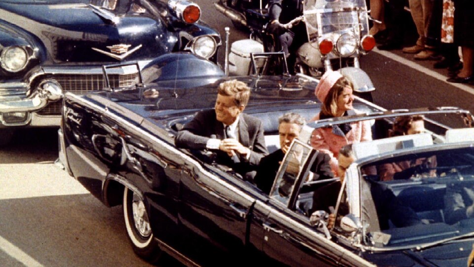 Une voiture conduit le président Kennedy dans une rue de Dallas le 22 novembre 1963.