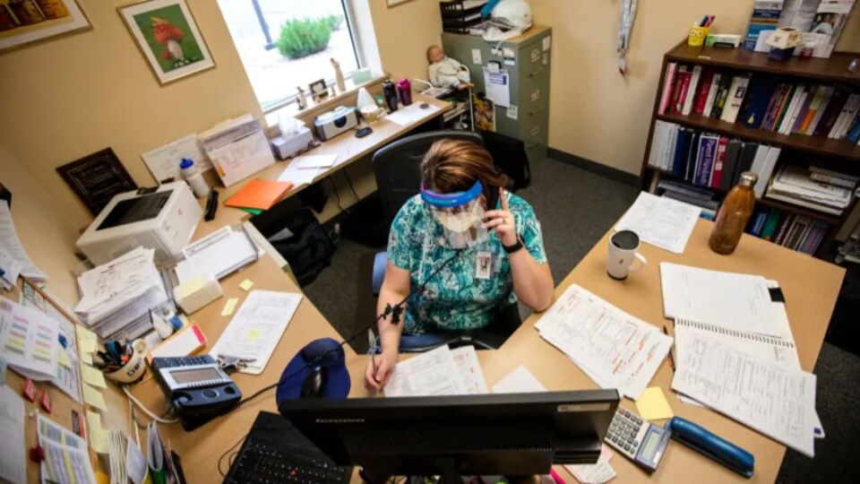 Une employée responsable du traçage de contacts dans son bureau.