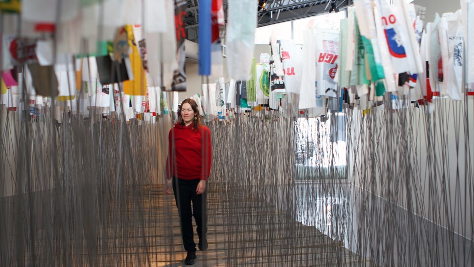 Une femme marche à travers une installation dans la galerie d'un centre d'artistes.