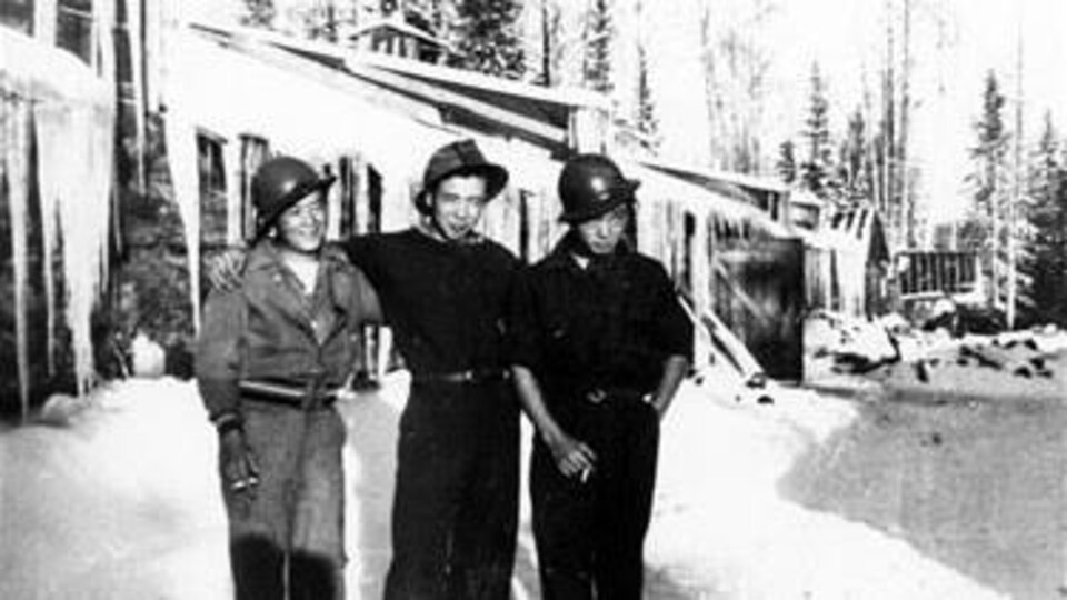 Trois citoyens canadiens d'origine japonaise deavnt un camp de travail à Slave Lake durant la Deuxième guerre mondiale