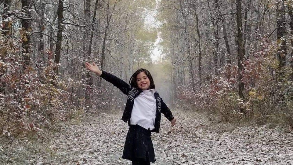 Isabelle d'Eschambault, jeune actrice de 11 ans. Elle est au milieu d'un sentier bordé d'arbres.