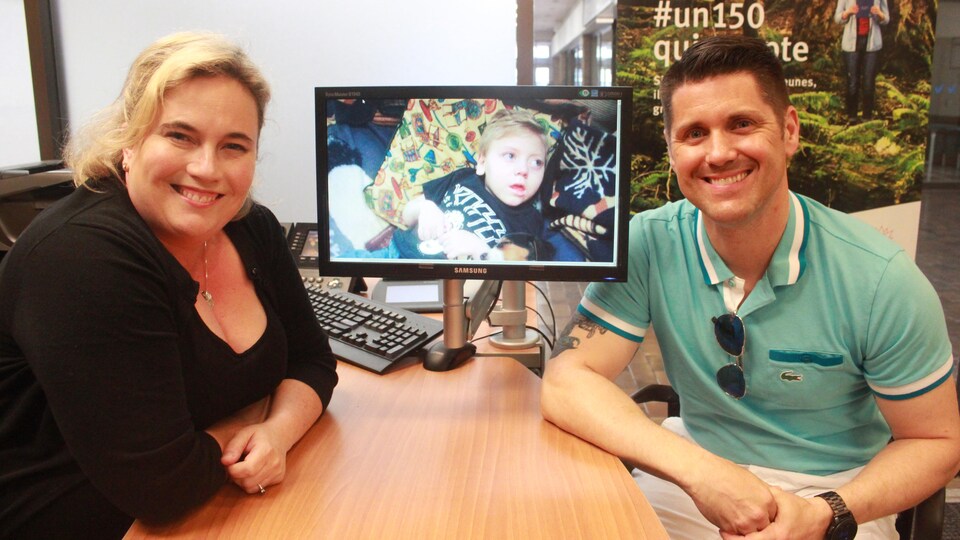 Jacquelyn Standing et Jason Chenier à un bureau où on peut apercevoir une photo de Sacha.