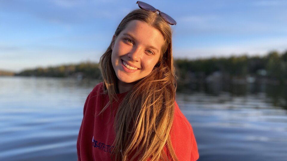 Elle pose tout sourire devant un lac