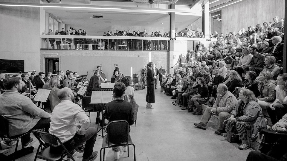 Musiciens, maître d'orchestre et le public lors d'une prestation à l'École d'architecture au centre-ville.