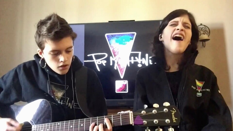 Candice est derrière une guitare alors qu'Emily chante.