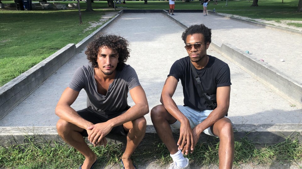 Robin et Georges assis au bord d'un terrain de pétanque