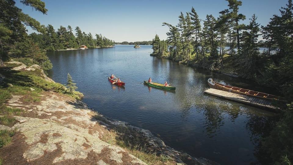 Deux canots quittent un quai pour se rendre à l'île Voyageur.