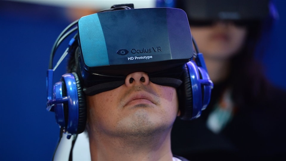 Un jeune fait l'essai d'un masque de réalité virtuelle Oculus.