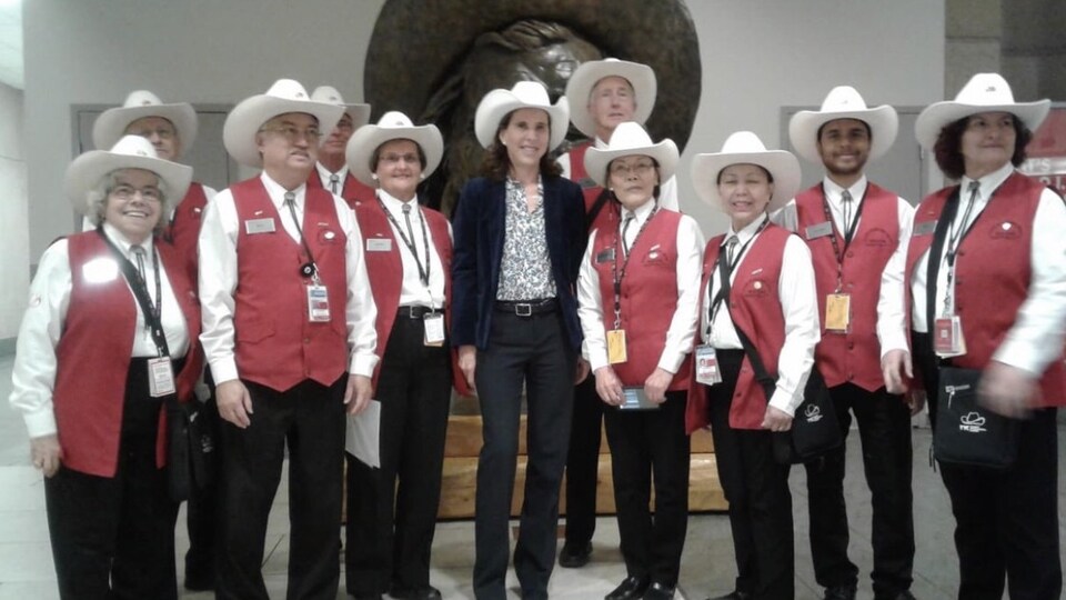 L'ambassadrice de France est entourée de bénévole de l'aéroport de Calgary.