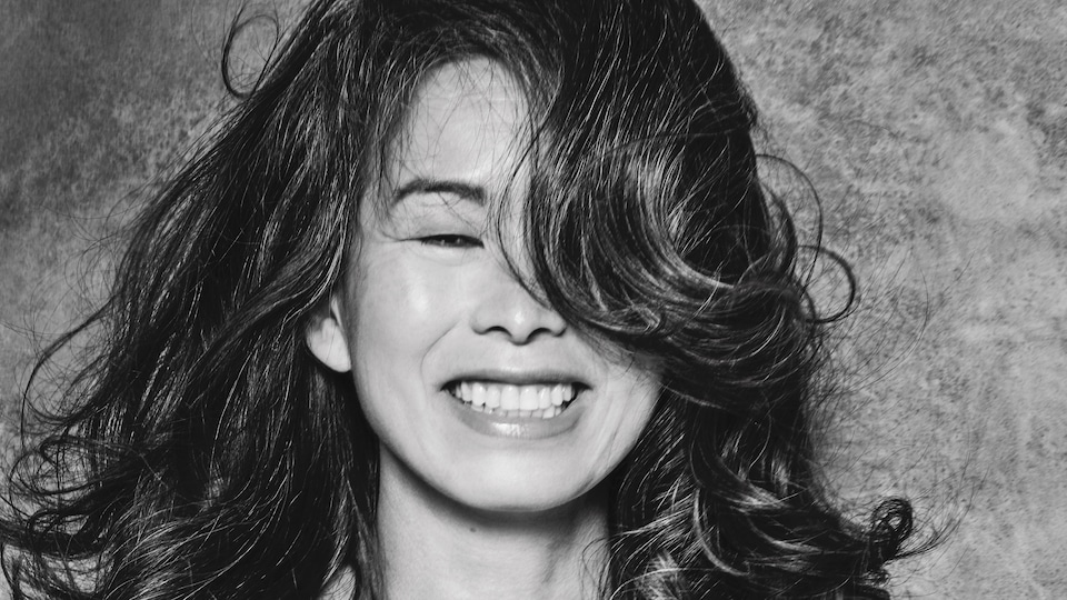 L'autrice Kim Thùy, souriante, les cheveux frisés.