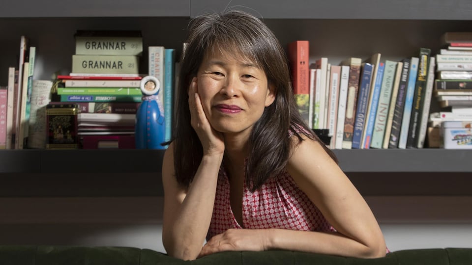 L’auteure Kim Thúy dans sa résidence de Longueuil, devant des tablettes de livres, le 11 juin 2019.