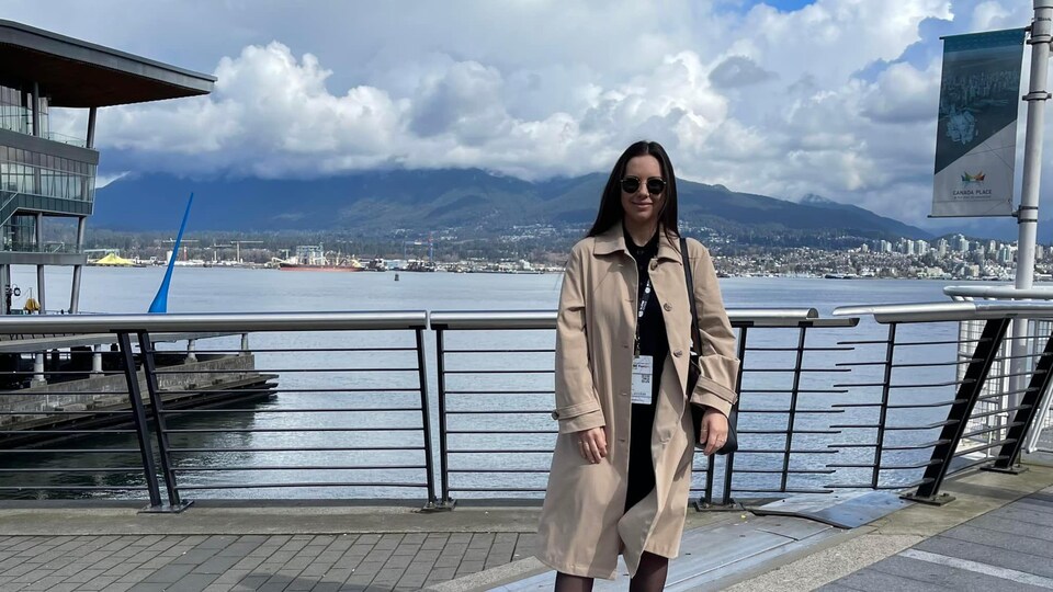 Kristina Michaud sur un quai à Vancouver avec les montagnes en arrière plan.