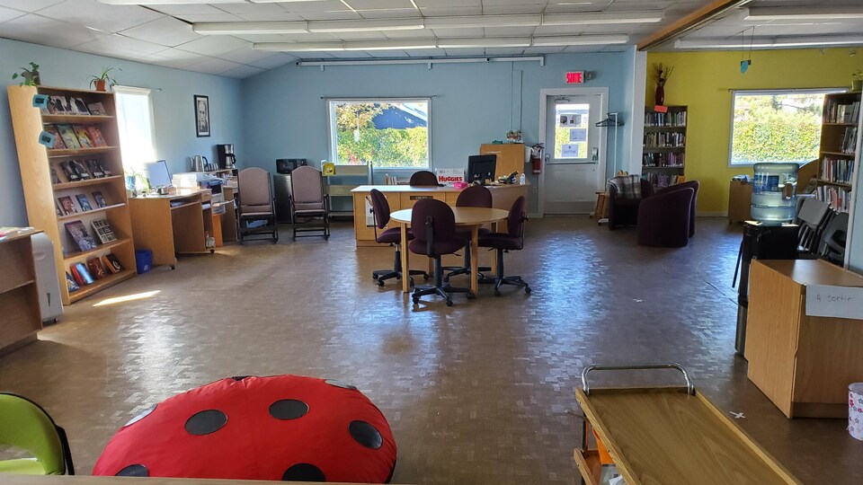 L'espace de la bibliothèques avec des chaises, tables et coussins.