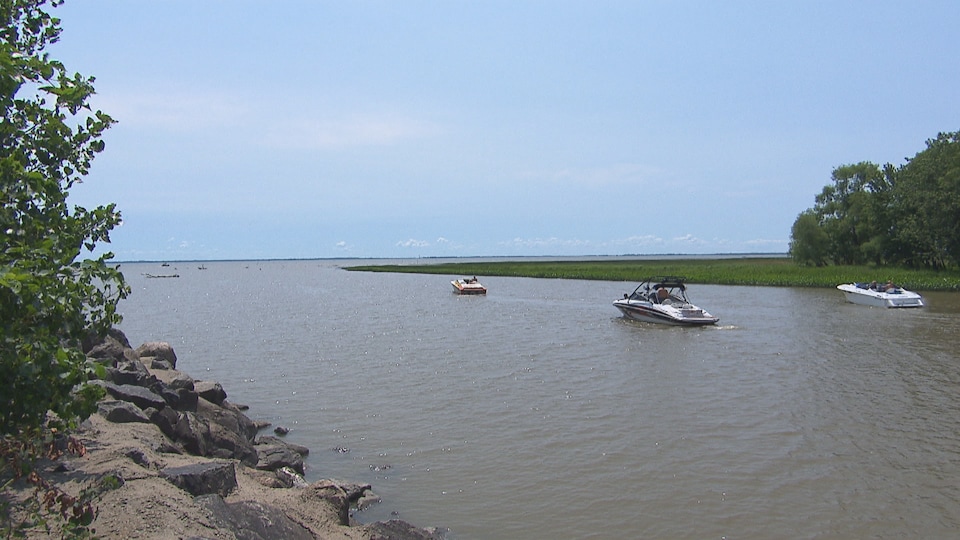 Une rivière avec trois bateaux.