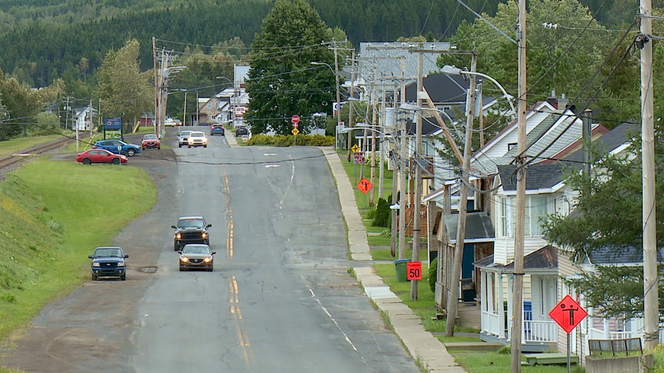 Une rue d'une petite municipalité avec des maisons et des automobiles .