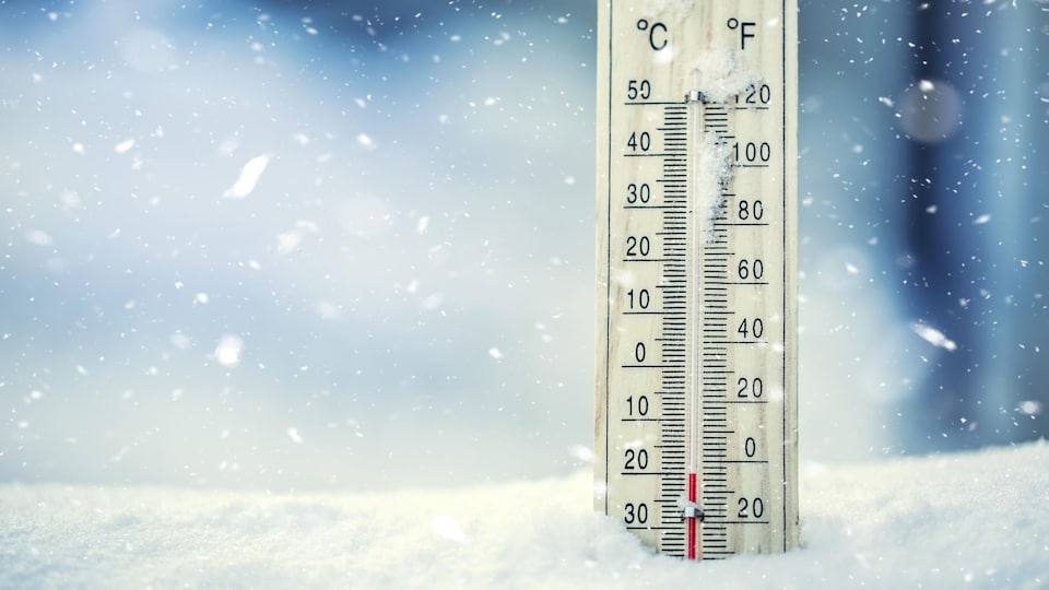 Un thermomètre est enseveli dans la neige.