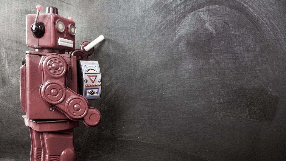Un robot écrit sur un tableau avec une craie.