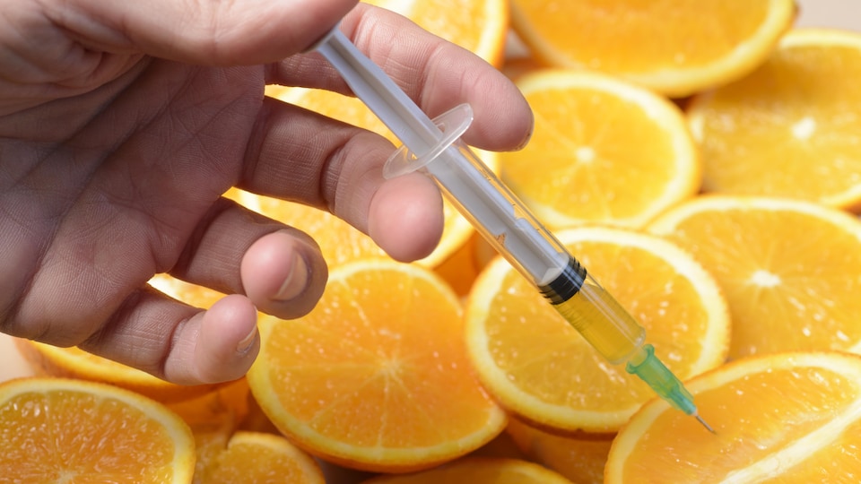 Une seringue dans des oranges, pour symboliser la vitamine C et les injections. 