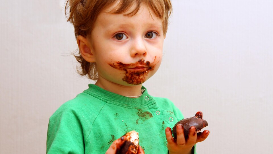 Un garçon avec la figure barbouillée de chocolat.