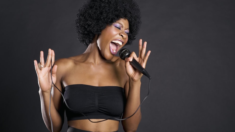 Une femme chante dans un micro.