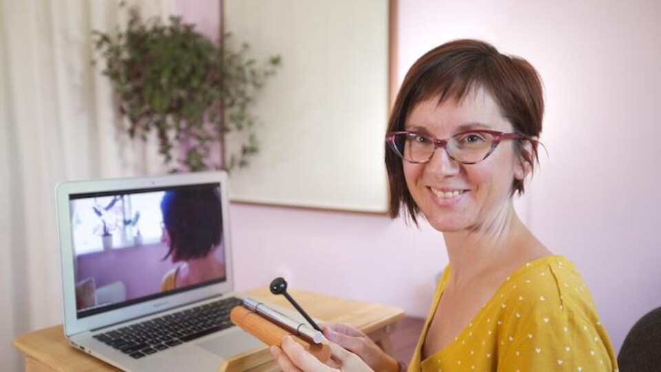 Laure Sabini assise à son bureau devant son ordinateur