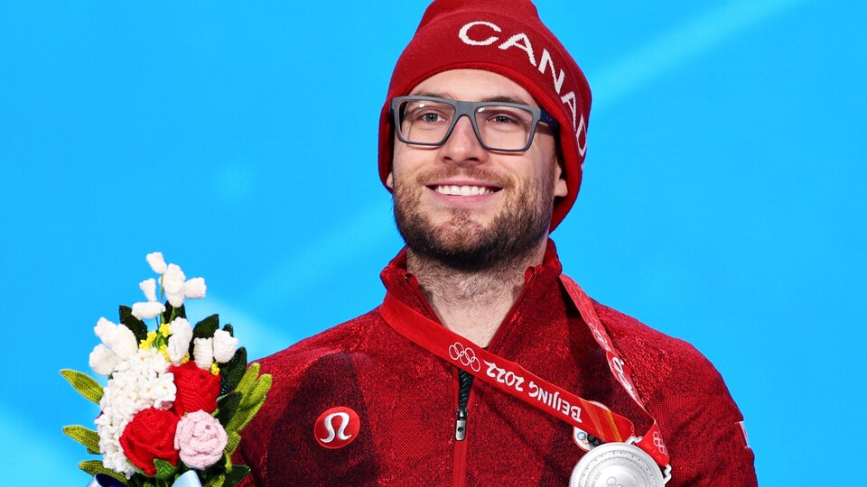 Laurent Dubreuil holds his silver medal and bouquet.