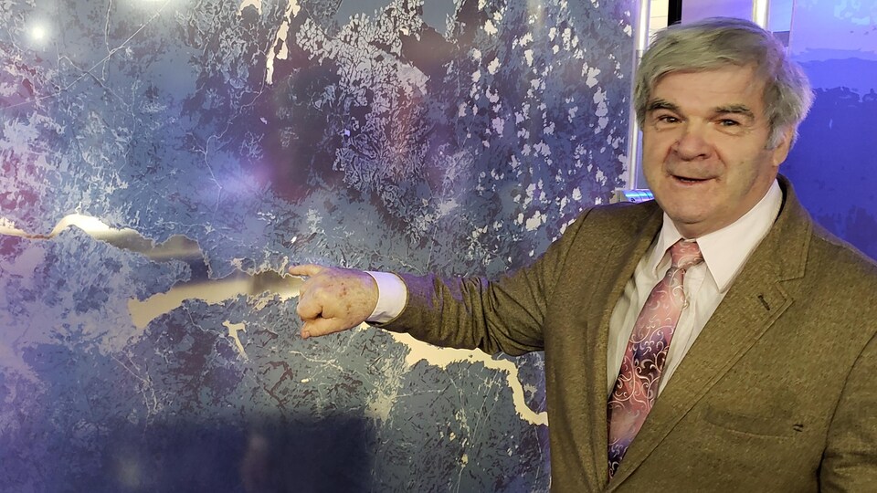 Laurent Thibeault indiquant où se trouve son village sur une carte