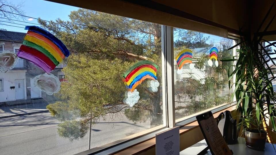 Des arcs-en-ciel peints dans les fenêtres d'une résidence.